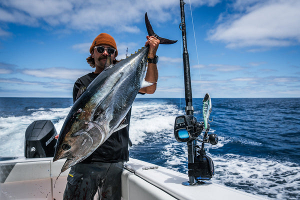 A man holding a fishing next to his fishing setup