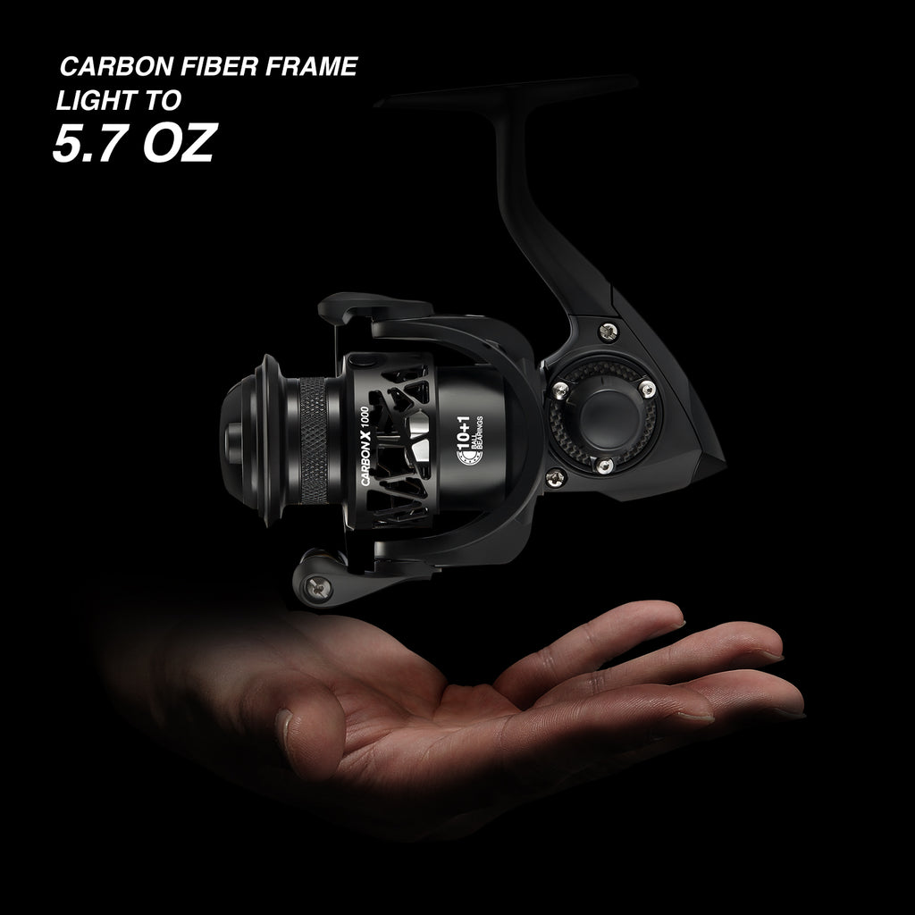 A hand holding a black fishing reel with easy bite detection titanium tip and lightweight hybrid carbon fiber blank.