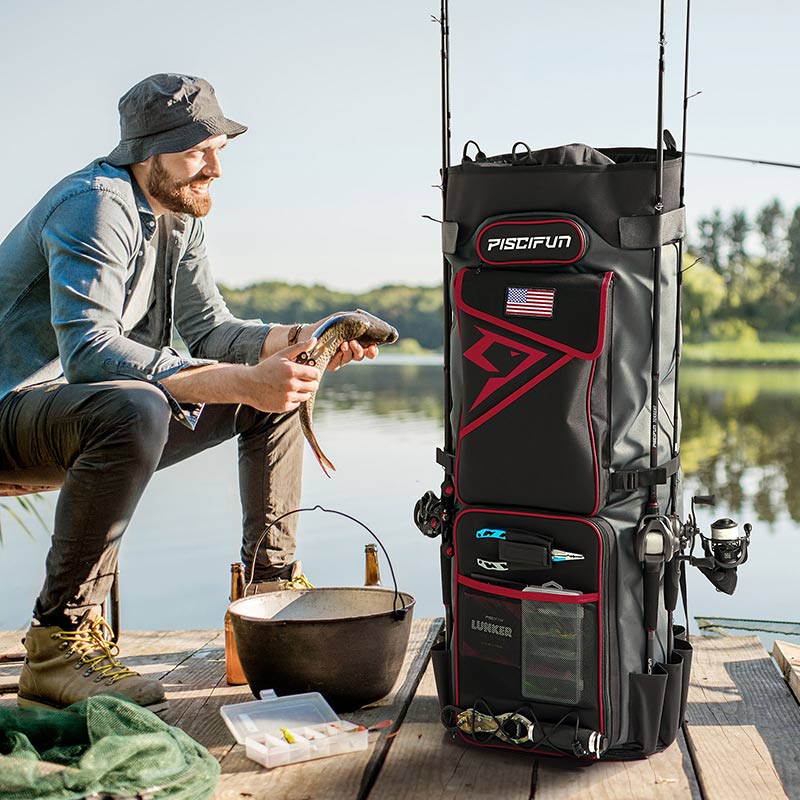 A man sitting on a dock holding a fish, with a black and red bag containing fishing rods and fishing poles beside him. The Piscifun Fishing Rod Case Bag holds 8 rods & reels, providing spacious storage for fishing gear and clothing. Ideal for any fishing adventure.